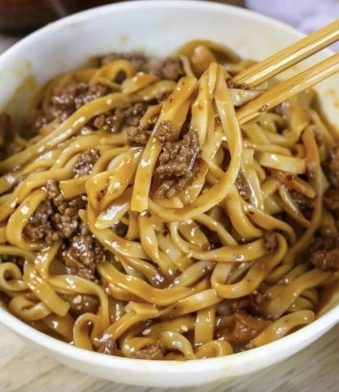 Plate of Mongolian ground beef noodles garnished with vegetables