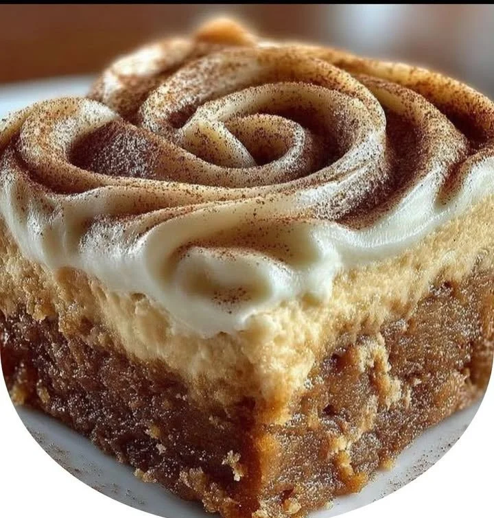Deliciously moist Pumpkin Spice Gooey Cake topped with cream and spices.