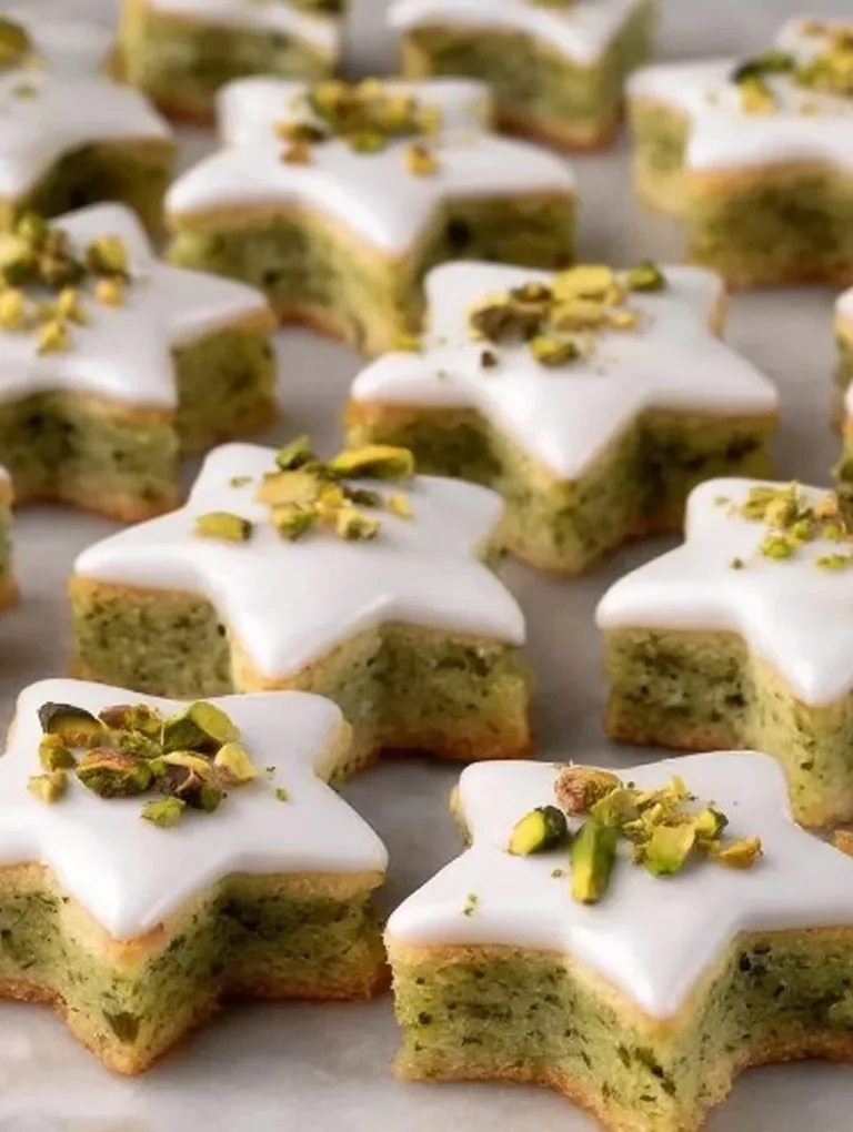 Baked pistachio stars topped with green pistachios and icing sugar