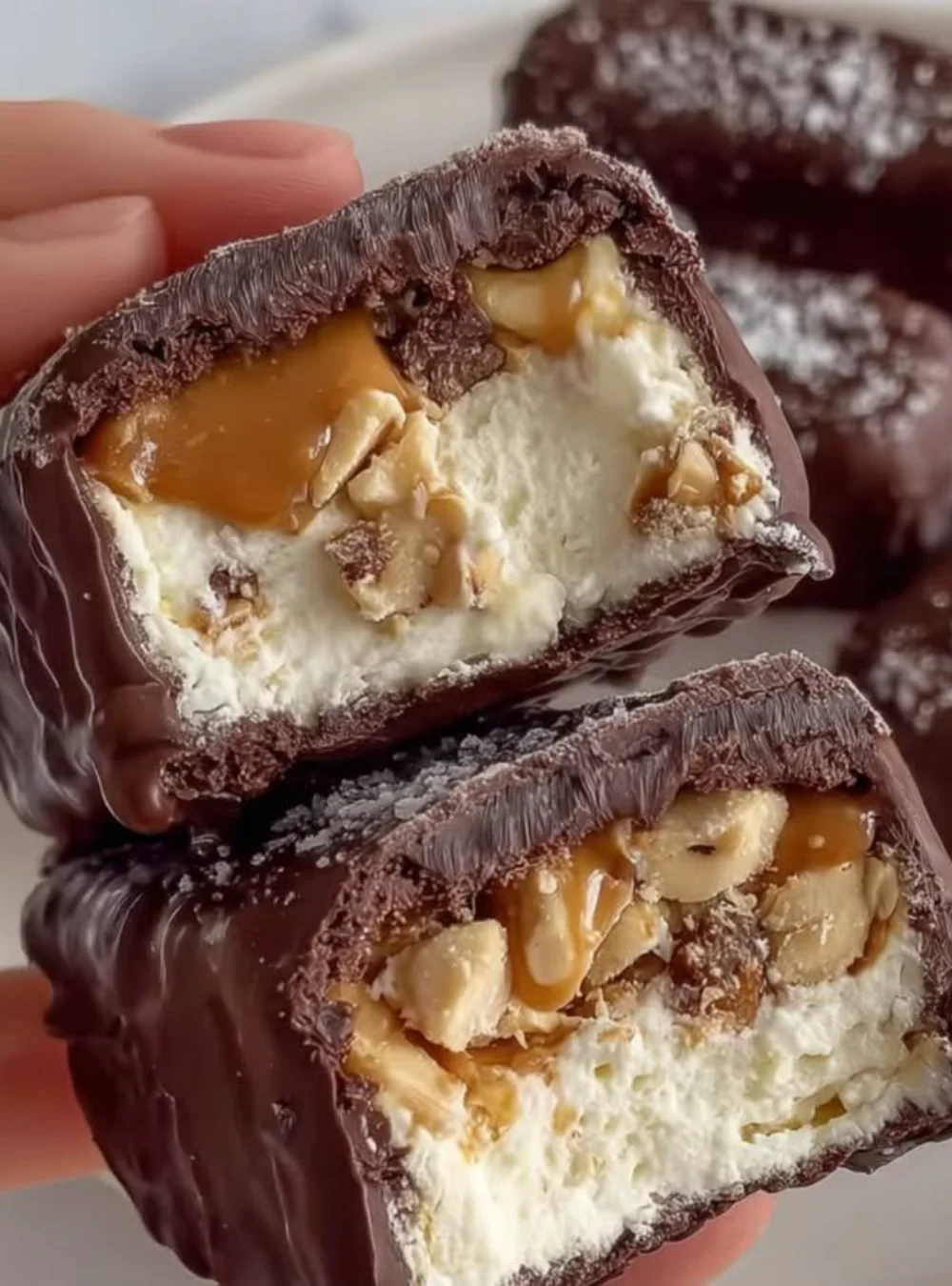 Homemade Snickers Bars with chocolate, caramel, and nuts on a plate