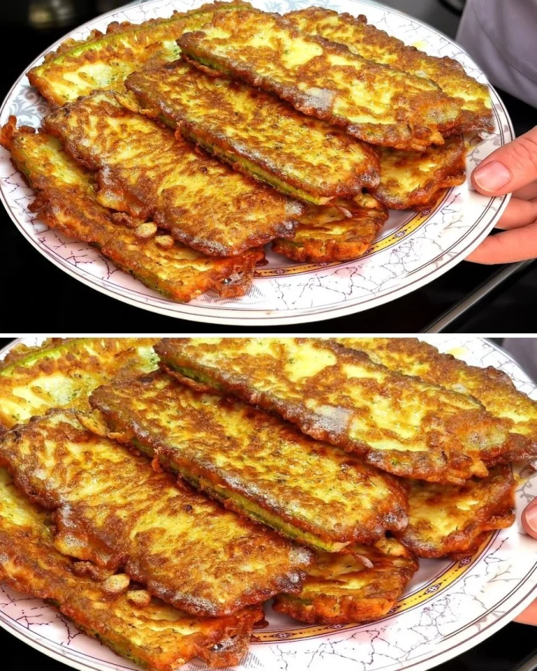 Cheesy zucchini dish served on a plate with fresh herbs.